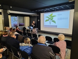 Kobieta stoi przed seniorami.