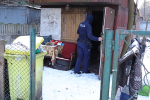Policjant zaglądający do pustostanu.