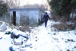 Policjant idący między pustostanami.