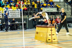 Dziewczynka przeskakuje przez skrzynię.