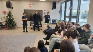 Policjanci stoją przed uczniami.