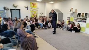 Policjanci stoją przed uczniami.