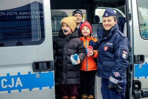 Policjantka z trójką dzieci w radiowozie.