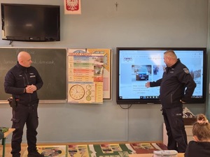 Policjanci stoją przed dziećmi.