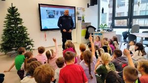 Policjant stoi przed grupą dzieci.