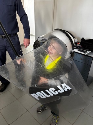 Dziecko z tarczą policyjną i w kasku policyjnym.