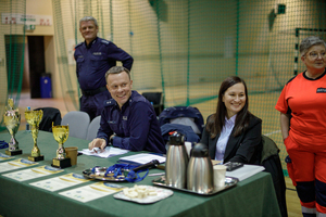 Policjant i kobieta siedzą za stołem.