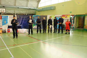 Rozpoczęcie turnieju - policjanci stoją na tle reklam honorowych patronatów.