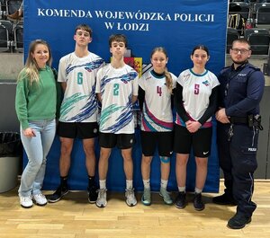 Zawodnicy stoją z policjantem i wychowawcą.