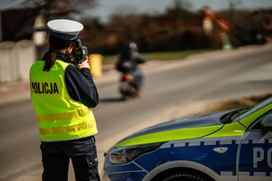 Policjantka mierzy prędkość motocyklowi.