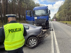 Na zdjęciu policjant oraz pojazdy biorące udział w wypadku.