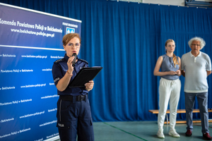 Policjantka mówi do gości przez mikrofon.