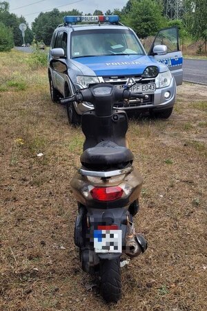 Motorower stoi przed radiowozem.