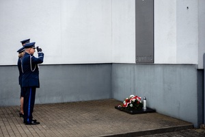 Oficerowie oddają honor przed tablicą pamiątkową.