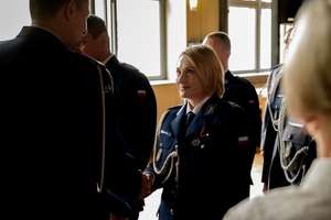 Policjantka otrzymuje gratulacje od komendanta.