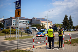 Policjanci sprawdzają oznakowanie oraz infrastrukturę przejścia dla pieszych w okolicy szkoły.
