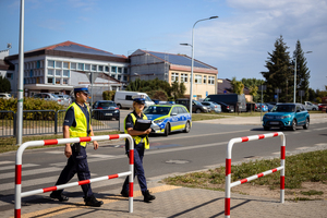 Policjanci sprawdzają oznakowanie oraz infrastrukturę przejścia dla pieszych w okolicy szkoły.