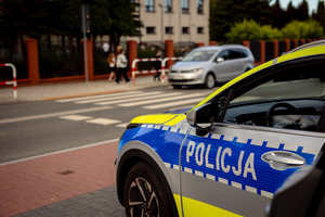 Policjanci dbają o bezpieczeństwo przy przejściu dla pieszych obok szkoły.