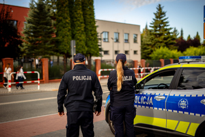 Policjanci dbają o bezpieczeństwo przy przejściu dla pieszych obok szkoły.
