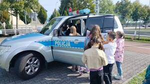 Dzieci przy radiowozie policyjnym.