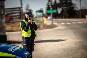 Policjantka mierząca prędkość na drodze.