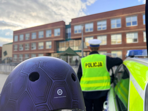 Kask, w tle policjant.