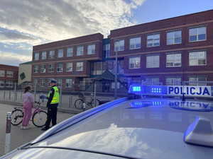 Policjant kontroluje dziewczynkę na rowerze.