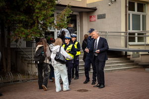 Policjanci ze starostą rozdają elementy odblaskowe młodzieży.