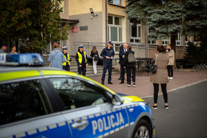 Policjanci ze starostą rozdają elementy odblaskowe.