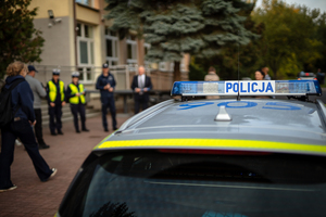 Policjanci ze starostą rozdają elementy odblaskowe.