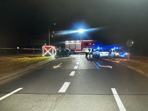 Policjanci pracujący na miejscu zdarzenia drogowego.