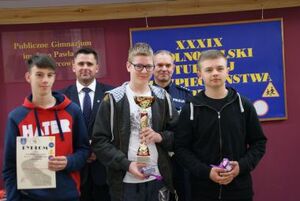 zwycięzcy turnieju, za nimi policjant.