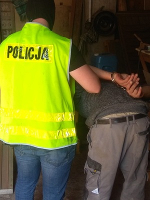 Policjanci prowadzą zatrzymanego